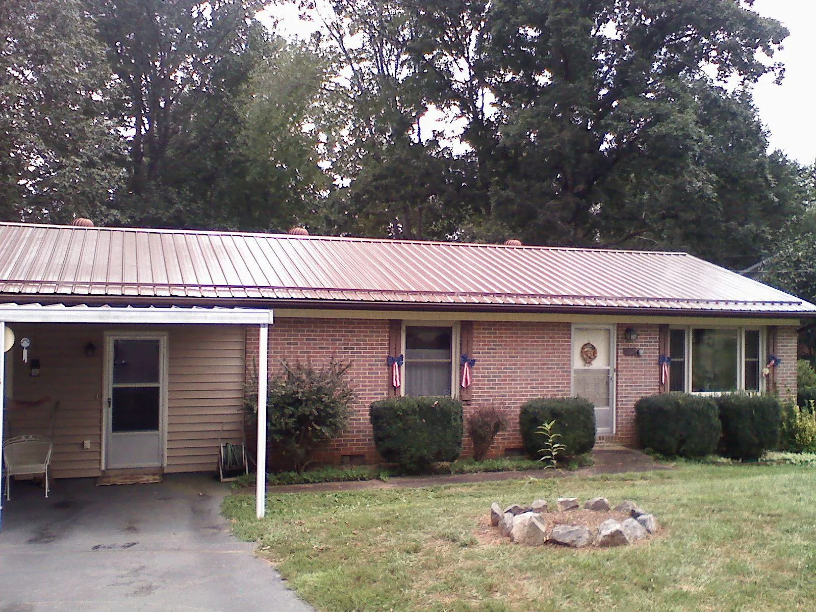 Bronze metal roof and carport on a brick ranch home — Roof Repair work by our crew in Whitt